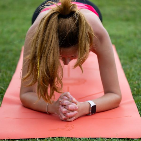 Woman performing a core-strengthening yoga exercise on a mat.